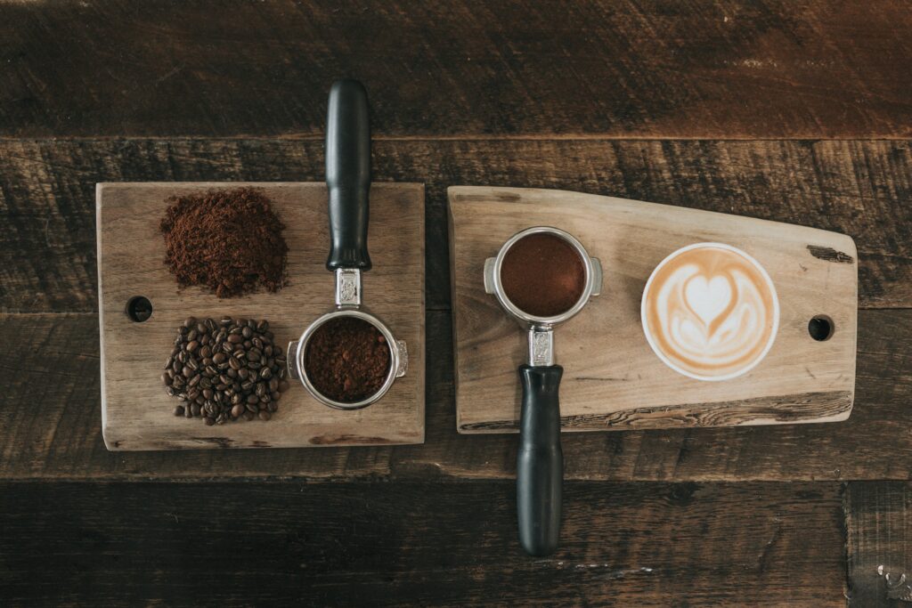 木のまな板の上に置かれたコーヒー豆とコーヒーミル