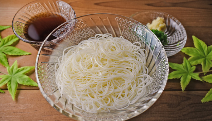 ガラスの器に入った、そうめんとめんつゆと薬味